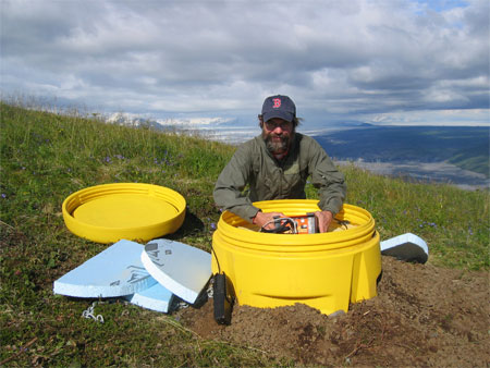 Dr. Gary Pavlis installs a seismometer at the hills above Bering Glacier in Alaska.